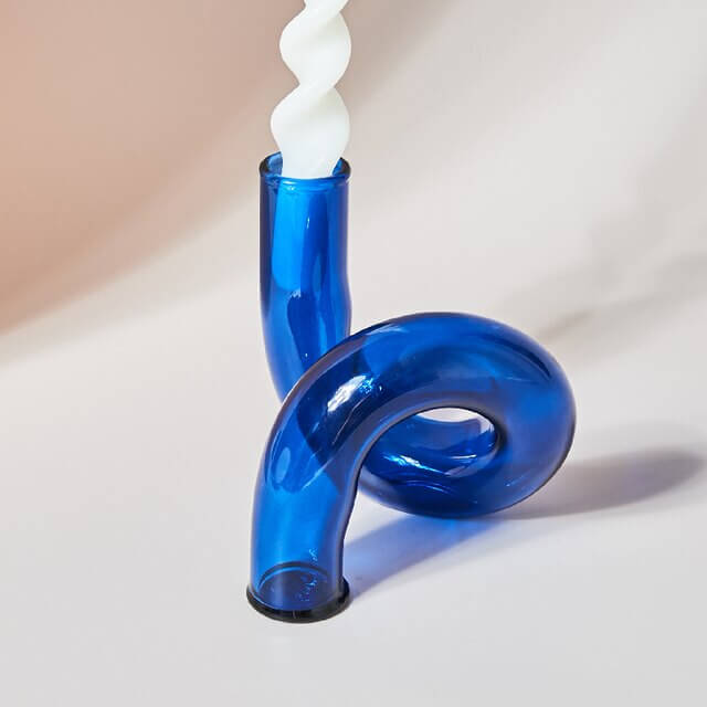 Blue glass candle holder with white spiral candle
