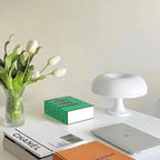Mushroom LED table lamp decor with tulips, books, and laptop.