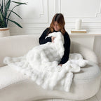 Woman with white fluffy blanket on couch