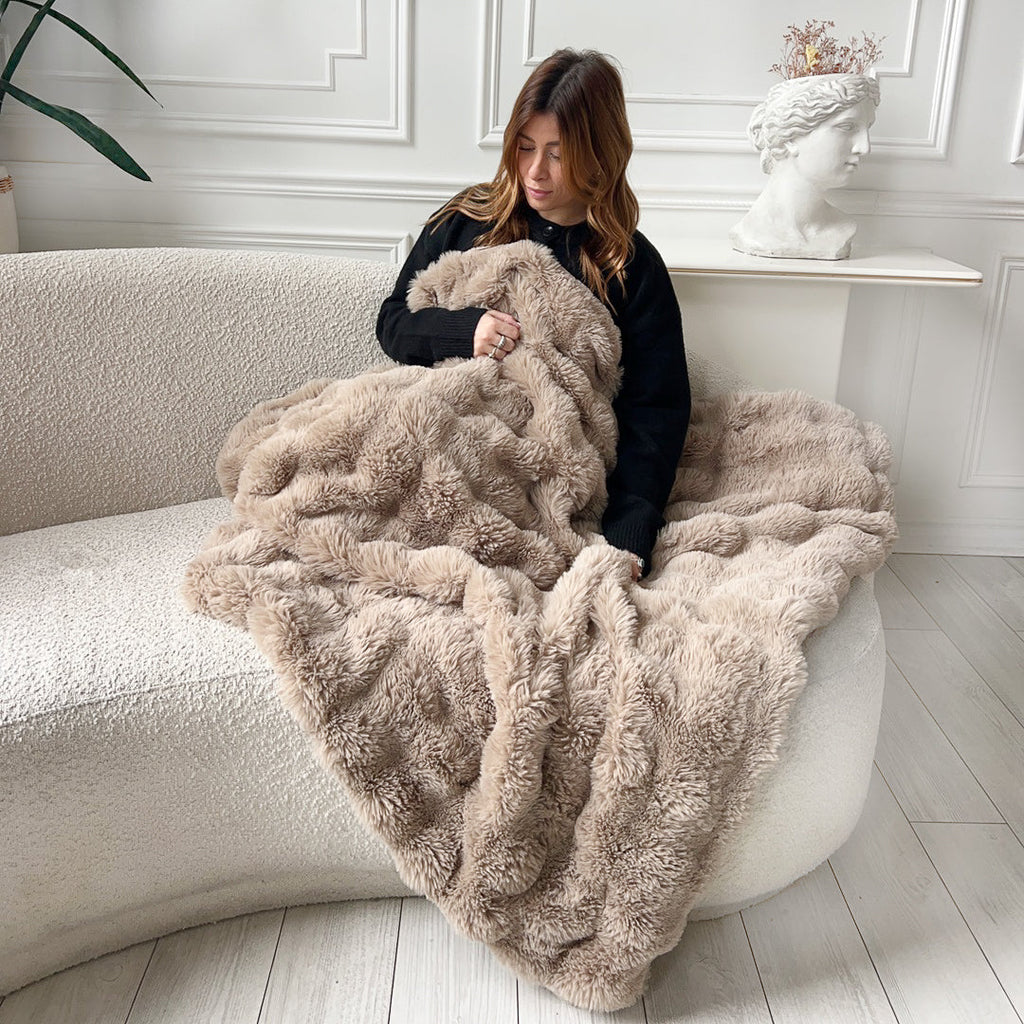 Woman with brown plush blanket on sofa