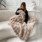 Woman with brown plush blanket on sofa